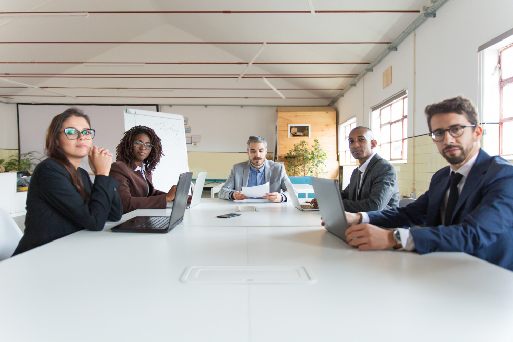 Executives in a leadership meeting discussing organizational development, behavior change, and practical leadership systems with Pinnacle Paths.